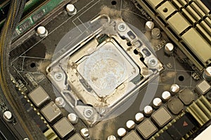 Very dirty computer processor. Dusty CPU microchip on a computer motherboard with traces of cooler grease. The electronic board