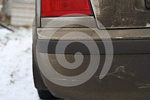 Very dirty gray car in the autumn or winter in the mud