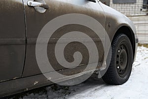 Very dirty gray car in the autumn or winter in the mud