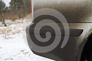 Very dirty gray car in the autumn or winter in the mud