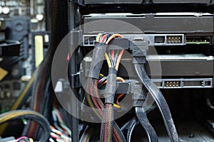 Very dirty wires with connectors are connected to the computer hard drive. HDD and SSD disc. Old colored wires in braided wrapper