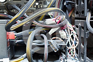 Very dirty wires, connectors and plugs in the computer. Old multi-colored wires in a braided wrapper. Stranded electrical wire