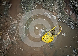 Very dirty yellow Shoe on the shore of a salt lake on a Sunny day