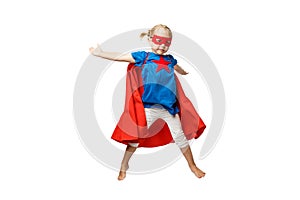 Very excited little girl dressed like superhero jumping isolated on white background.