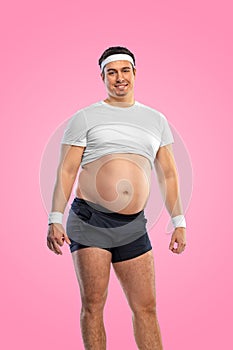 A funny fat man isolated on pink background. Obesity and eating disorder. Concept for dietetics and fitness advertising photo