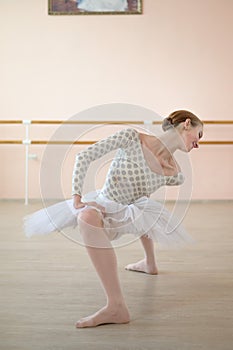 A very flexible ballerina in a tutu stands in a plie in a class with ballet machines. Hypermobility of joints and photo
