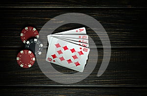 A very gambling game of poker with a winning combination of a royal flush. Cards with chips on a dark vintage table in a poker