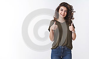 Very good. Cheerful supportive cute armenian girlfriend curly-haired show thumbs up encourage friend doing fine smiling