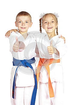 Very happy boy and girl athletes in karategi