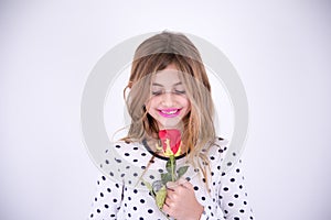 Very happy girl looking at red flower