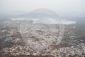 Very hazy, polluted aerial cityscape view from the Monsoon Palace of Udaipur, India
