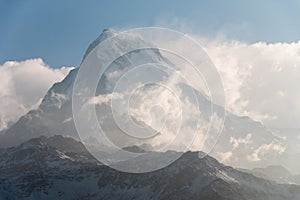 Very high snow mountain peak over the clouds level