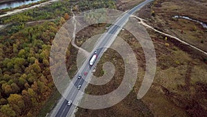 Very high up drone shot of red truck with trailer driving an interstate highway