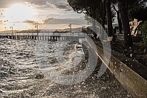 Very high water waves splashing on a lake shore, with drops coming very near to the camera