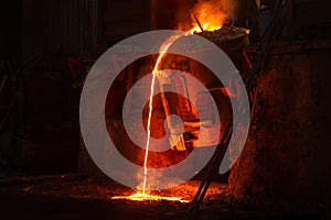 Very hot metal casting in a old steel factory photo