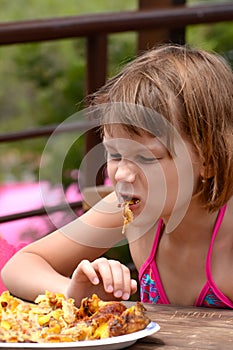 Very hungry girl eats grilled chicken