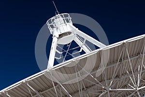 Very Large Array close view of underside of a radio antenna dish VLA against a deep blue sky, space exploration