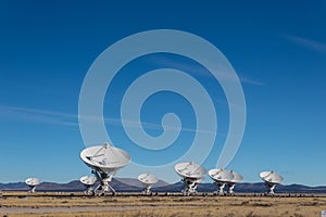 Very Large Array Distant view of numerous dish antennas pointing toward a blue sky, science technology space exploration photo