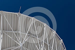 Very Large Array graceful arch of a large radio telescope dish against blue sky, science engineering