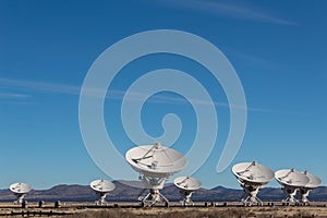 Very Large Array grouping of radio antenna dishes in New Mexico desert, blue sky photo