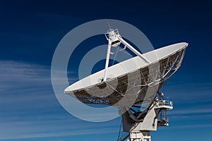 Very Large Array huge white radio satellite dish isolated against a dark blue sky
