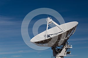 Very Large Array radio satellite dish antenna isolated against a deep blue sky