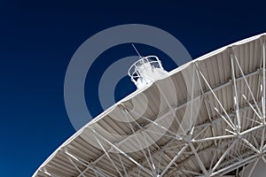 Very Large Array radio telescope dish pointing into a deep blue sky, science technology