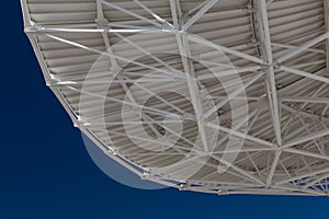 Very Large Array view from bottom of a radio satellite dish at the VLA against a deep blue sky