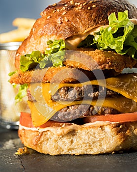 A very large burger with two crispy chicken patties and two bovine meat patties