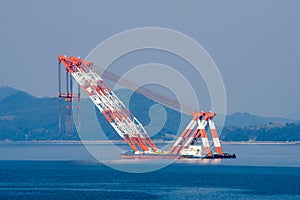 Very large floating crane anchors in the bay photo