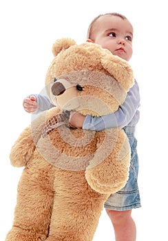 Very little boy hugging big teddy bear
