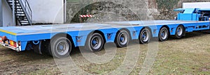 very long blue truck with six axles of wheels