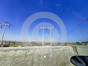 A very long and tall electric supply chain of tall metal towers on the top of dried mountains