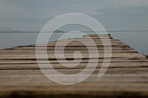 Very low first person view of a pier on Trasimeno lake Umbria, with perfectly still water