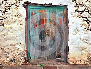 A very old, ailing and with the most diverse paint residues provided wooden door with two wing doors