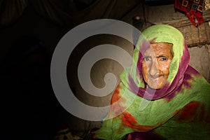 A very old Asian woman with a sad expression and wrinkles on her face
