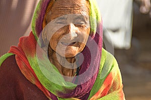 A very old Asian woman with a sad expression and wrinkles on her face