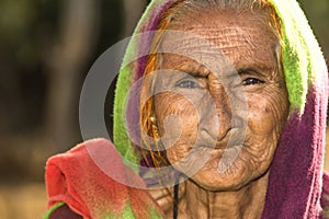 A very old Asian woman with a sad expression and wrinkles on her face