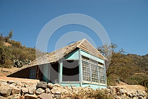 a very old blue house against a blue sky