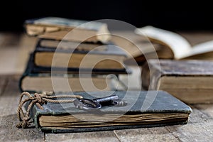 Very old book and key on an old wooden table. Old room, wooden t