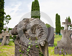 An very old broken statue of Mary old cemetery. Overgrown with ivy concept death, religion