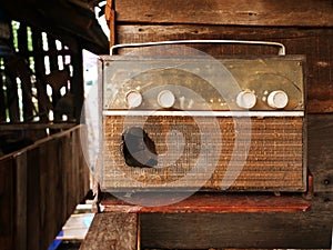 A very old, damaged radio player with an old picture background