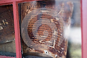 Very old died out Wanted sign behind a glass