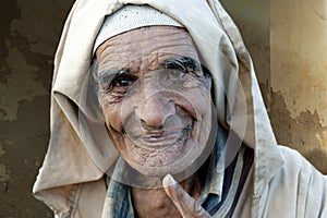 Old wrinkled man explains traditional clay technique to travelers. Wise, friendliy man, Marrakech, Morocco