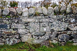 Very old hand made stone wall near the Ardbeg distillery in Scotland UK