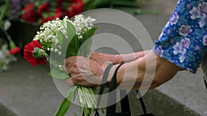 Very old lady with flowers at memorial day.