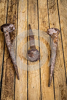 very old large nails on a beautiful wooden background, rusty
