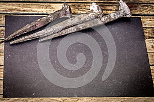 very old large nails on a beautiful wooden background, rusty