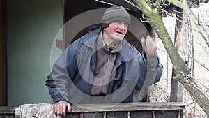 A very old man inspects garden trees in the spring before flowering removes extra branches preparing for the new season