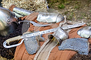 Ancient Medieval Knights' Equipment: Sword and Iron Gloves on an Outdoor Desk